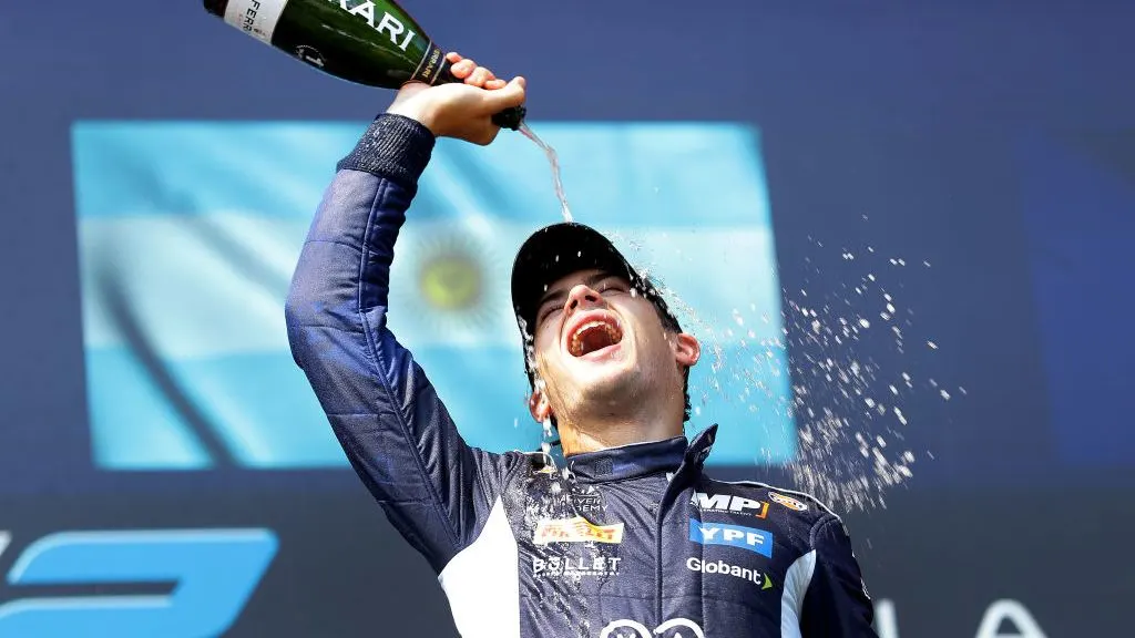 Franco festeja con champagne en el podio tras su primera victoria en Fórmula 2 en Imola.